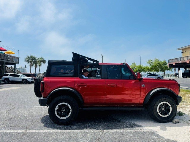 Ford Bronco with the soft top open near the beach